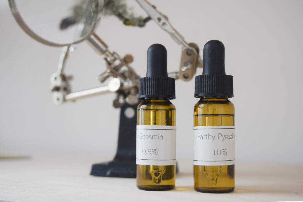 Fragrance dropper vials sitting in front of a magnifying glass