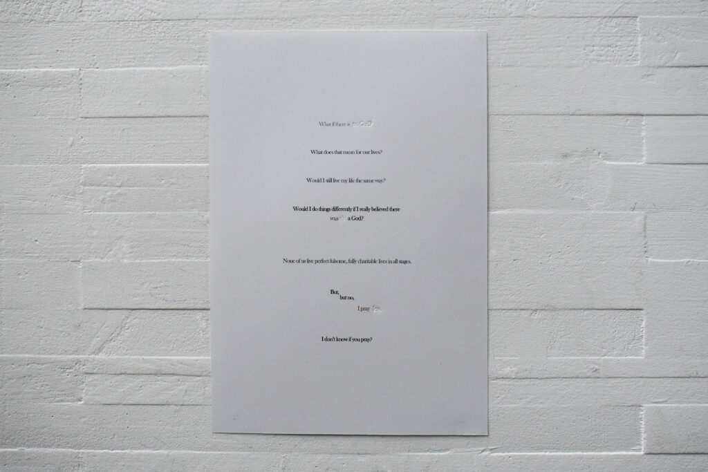 A3 print of concrete poetry with black, red and inklessly debossed words against a white brick background